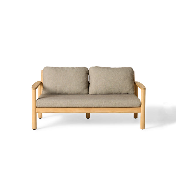 The Stinson Loveseat by Terra Outdoor Living with teak frame and Italian rope seat back, shown with weather-friendly cushions—features gently curved lines and vertical slats for a wraparound silhouette inspired by a curved beach; includes one long seat cushion and two plush back cushions.